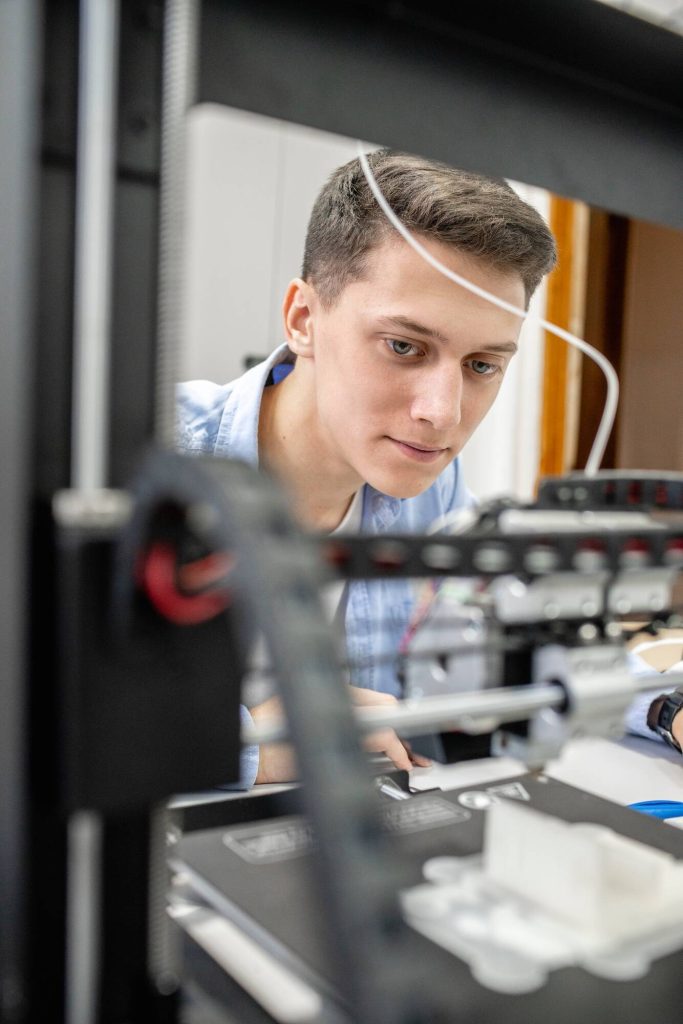 3d printing expert setting up 3D printer, close up